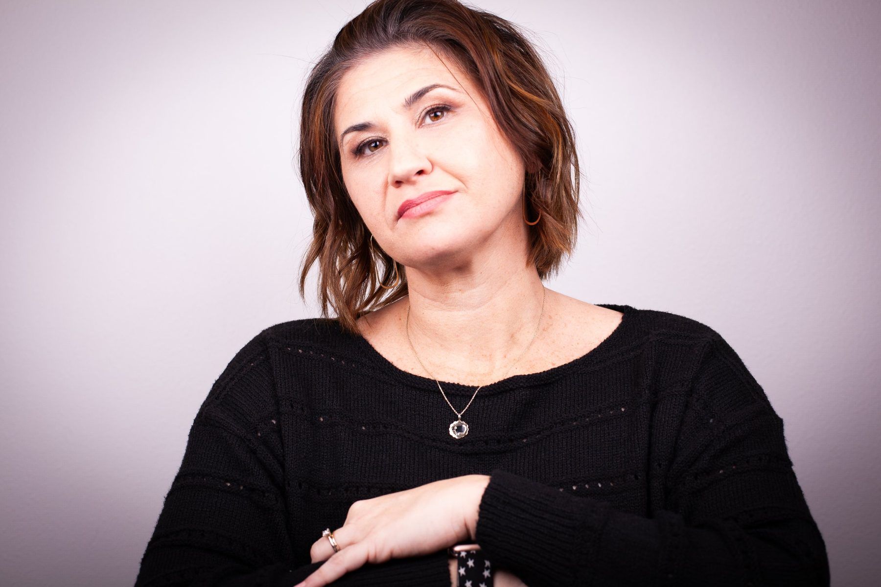 Lori Lackland in a black sweater, looking at the camera with a calm, direct expression.